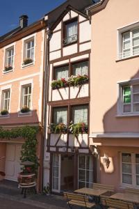贝尔恩卡斯特尔-库斯Mosel Röschen的窗户上布满盆栽植物的建筑