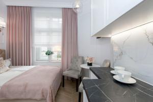 索波特La Boutique Studio Sopot的配有一张床、一张书桌和一扇窗户的酒店客房