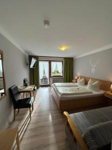 斯陶达奇格达赫祖姆奥特酒店的一间卧室配有两张床、一张桌子和一把椅子