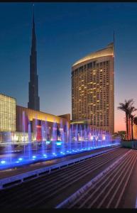 迪拜Emaar Fashion avenue-Formerly Address Dubai Mall Residence的前面有蓝色灯的大建筑