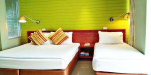 七岩差安长海滩酒店的绿墙客房的两张床
