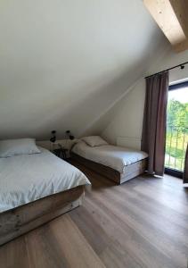 魏斯布里阿赫Weißbriach Lodge的一间卧室设有两张床和大窗户