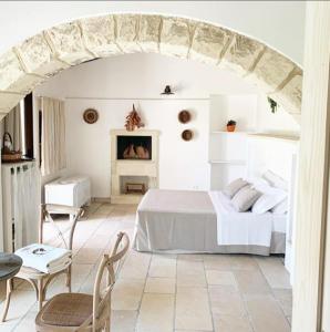 阿卡亚马塞里亚维多利亚乡村民宿的白色卧室配有床和桌椅