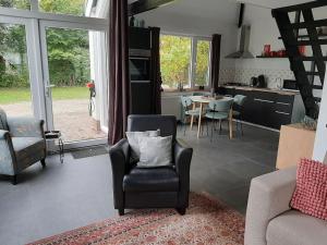 PosterholtVrijstaande recreatievilla met ruime omheinde tuin的客厅配有沙发、椅子和桌子