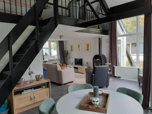 PosterholtVrijstaande recreatievilla met ruime omheinde tuin的一间带螺旋楼梯的客厅和一间客厅。