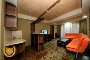 博尔若米博尔若米宫殿健康Spa中心酒店的客厅配有橙色沙发和桌子