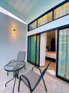Ban Khlong HaengBlue Ba You Resort的一间带桌椅的房间和一间带卧室的房间