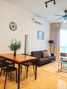 普特拉贾亚Staycationbyrieymona - 3BR Condo, CLIO 2, Putrajaya的客厅配有桌子和沙发