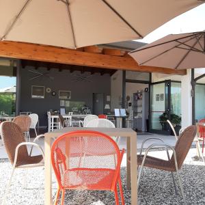 科拉迪拉齐塞Corte Mantovani的庭院里配有桌椅和遮阳伞
