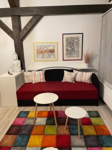 希格斯多夫Ferienwohnung Atelier的客厅配有红色的沙发和2张桌子