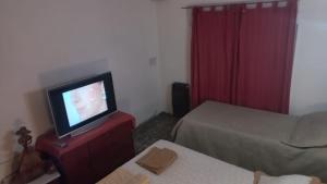圣路易斯Departamento La Argentina的一间设有两张床的房间和一个梳妆台上的电视