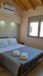 TavariLesvos Tavari bay的一间卧室配有一张床,上面有两条毛巾