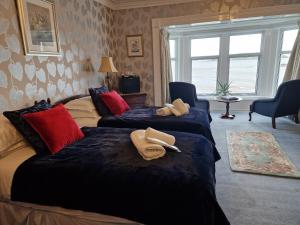 AuchencairnBalcary Bay Country House Hotel的两张位于酒店客房的床,配有毛巾