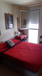 巴塞罗那"Casa TOLIMA"的一间卧室设有两张红色的床和窗户