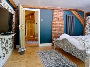萨弗伦沃尔登Captivating 9-Bed House Hot Tub Near Cambridge的一间设有床铺和砖墙的房间