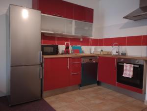 卡罗维发利Apartmán Rezidence Čertovka 2121 free parking garage的厨房配有红色橱柜和不锈钢冰箱