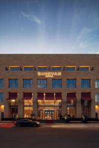 吉达SHIRVAN Hotel City Yard Jeddah的前面有停车位的建筑