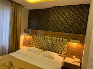 梅尔辛Grand Ezel Hotel的一间卧室配有一张大床和木制床头板