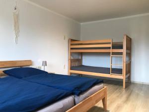 FriedlandGemütliche Ferienwohnungen in Friedland Ortsteil Cosa的一间卧室配有两张双层床和一张蓝色的床。