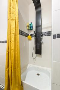 康布雷Apt Bohème, Parking Privé, Centre的浴室内设有带黄色淋浴帘的淋浴