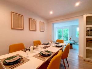 RixensartGenval - The Lake Side House的用餐室配有带橙色椅子的长桌