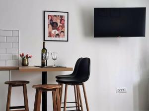 瓦拉日丁Studio apartman Mirta的一张桌子、一张黑椅子和一瓶葡萄酒