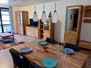 瓦尔兴湖Ferienwohnung am Walchensee的一间用餐室,配有一张带蓝色盘子的木桌