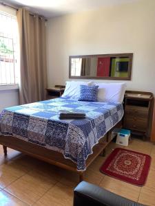 卡希亚斯公爵城Quartos Em Casa Caxias - Pousada Paraíso的一间卧室配有一张带蓝白色毯子的床