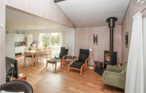 Kolby KåsBeautiful Home In Sams With Kitchen的客厅设有壁炉、桌子和椅子