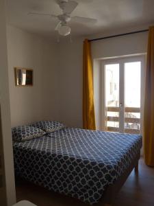 博尼法乔Duplex sur un fameux Grain de sable的一间卧室设有一张床和一个滑动玻璃门