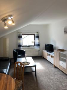 奥斯赛拜-塞林吕根岛公寓的客厅配有沙发和桌子