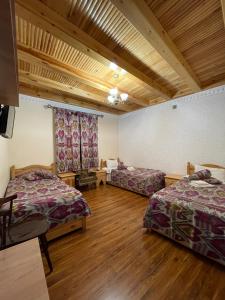 布哈拉Mutara Bukhara的铺有木地板的客房内的两张床
