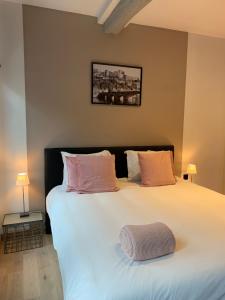 那慕尔Namur à Mur的卧室配有带粉红色枕头的大型白色床