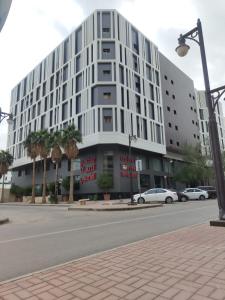 利雅德Manazel Al Diafa Serviced Apartments的一条城市街道上的白色大建筑