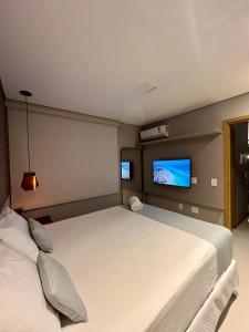 马塞约Elegante quarto e sala Sky Concept 418 Novissímo的一间卧室配有一张大床和一台平面电视