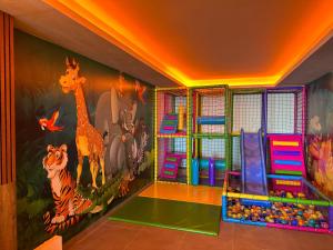 科帕奥尼克Milmari Apartments FREE SPA & PARKING Kopaonik的墙上挂着动物壁画的游戏室