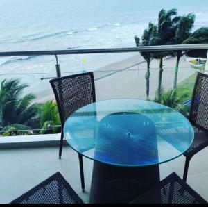 通苏帕Makana Tonsupa - Suites Familiares 311 y 421 - Deluxe Suites的海滩阳台的玻璃桌子和椅子