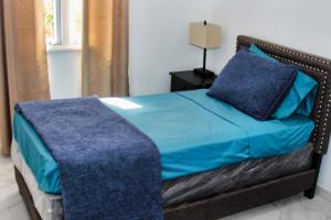 Oyster PondSea-Renity的一间卧室配有一张带蓝色床单和一盏灯的床。