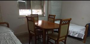地拉那Sina Hostel的一间带桌椅和一张床的用餐室