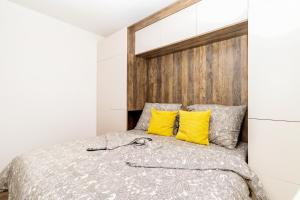 特里尼达古图Sardegna Appartamenti, Via Sedini的一间卧室配有一张带黄色枕头的床