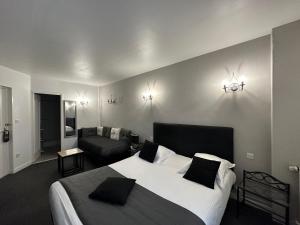 勒特雷波尔乐圣 - 伊夫酒店的一间卧室配有一张大床和一张沙发