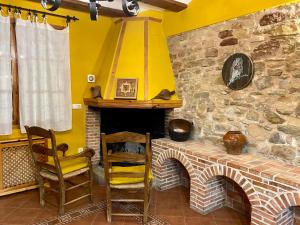 GalveCasa Rural La Yedra的一间设有两把椅子和石头壁炉的房间