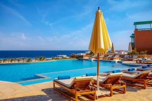 赫尔格达Zen Resort Sahl Hasheesh by TBH Hotels的一个带椅子和黄色遮阳伞的游泳池