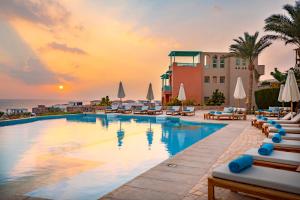 赫尔格达Zen Resort Sahl Hasheesh by TBH Hotels的一座位于度假村的游泳池,享有日落美景