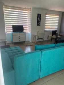 圣地亚哥Casa 3 habitaciones exclusiva valle lo campino的客厅配有蓝色的沙发和电视