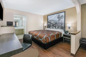 莫斯波因特Super 8 by Wyndham Moss Point的配有一张床和一张书桌的酒店客房