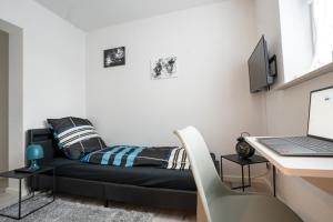 爱尔福特CaSa Apartment Svea - 2x Parken-Amazon Prime-Terasse-Garten-Vollausstattung的一间卧室配有一张床和一张带笔记本电脑的书桌