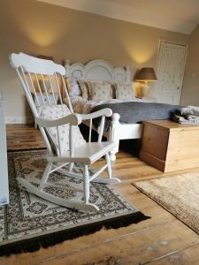 贝克尔斯Beehive Cottage的卧室配有白色摇椅和1张床