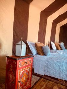 MhamidCouleur du désert的一间卧室配有两张床和一张带台灯的桌子