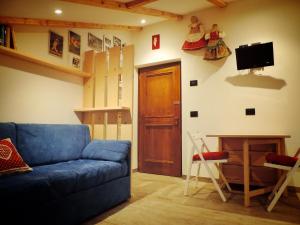 阿尔巴迪卡纳泽伊incantevole mansarda in val di Fassa的客厅设有蓝色的沙发和木门。